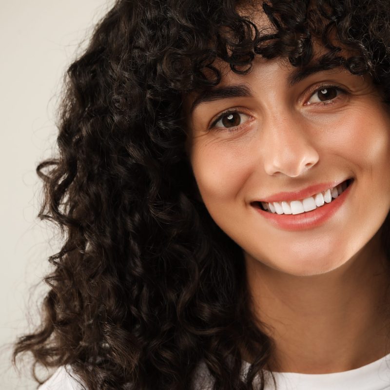 Happy,Young,Woman,On,Light,Grey,Background,,Closeup.,Dental,Veneers